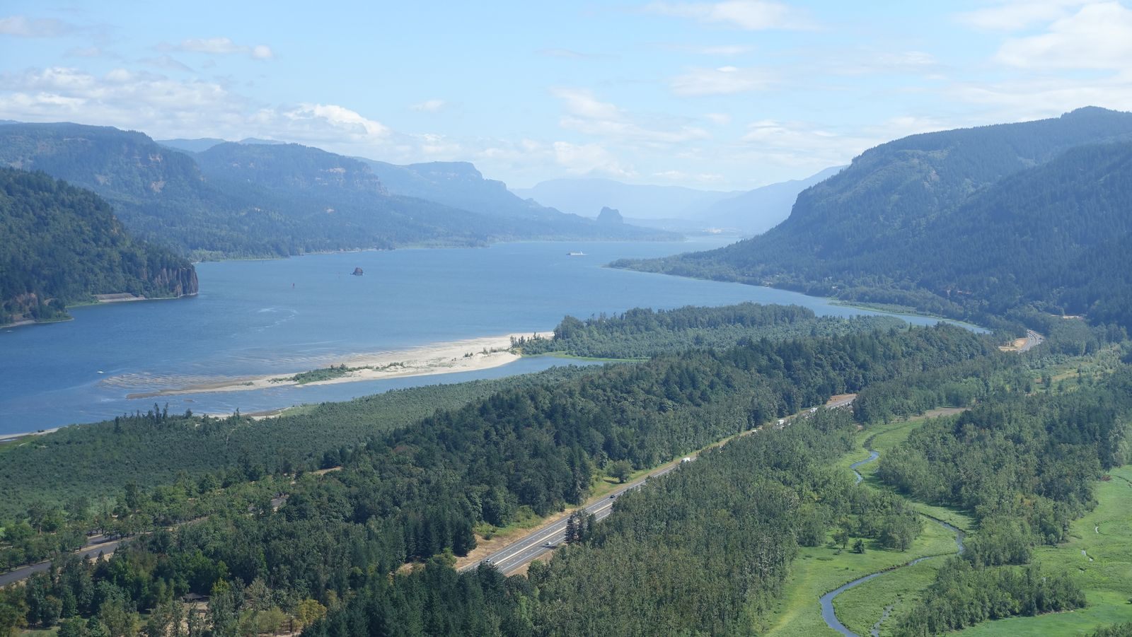 Aerial view of the Columbia River Gorge with forested cliffs and the river, where many things to do in Oregon begin
