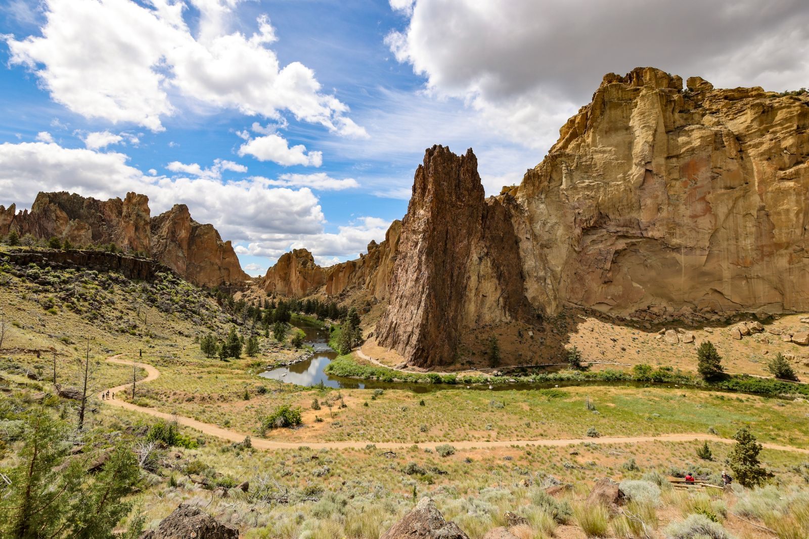 Orange volcanic cliffs and a trail through sagebrush at Smith Rock State Park in Central Oregon